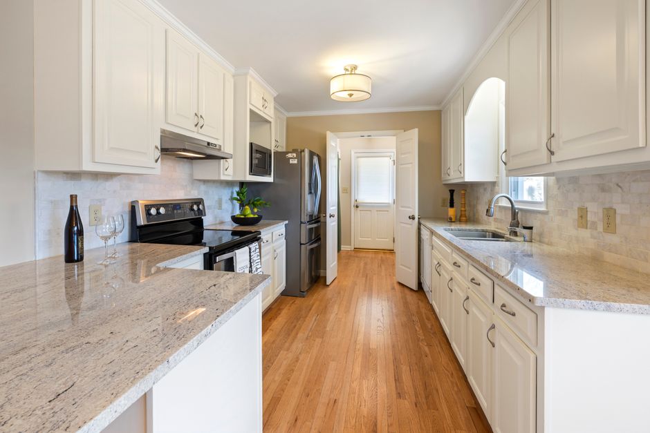 Spacious white kitchen featuring elegant countertops and modern appliances.